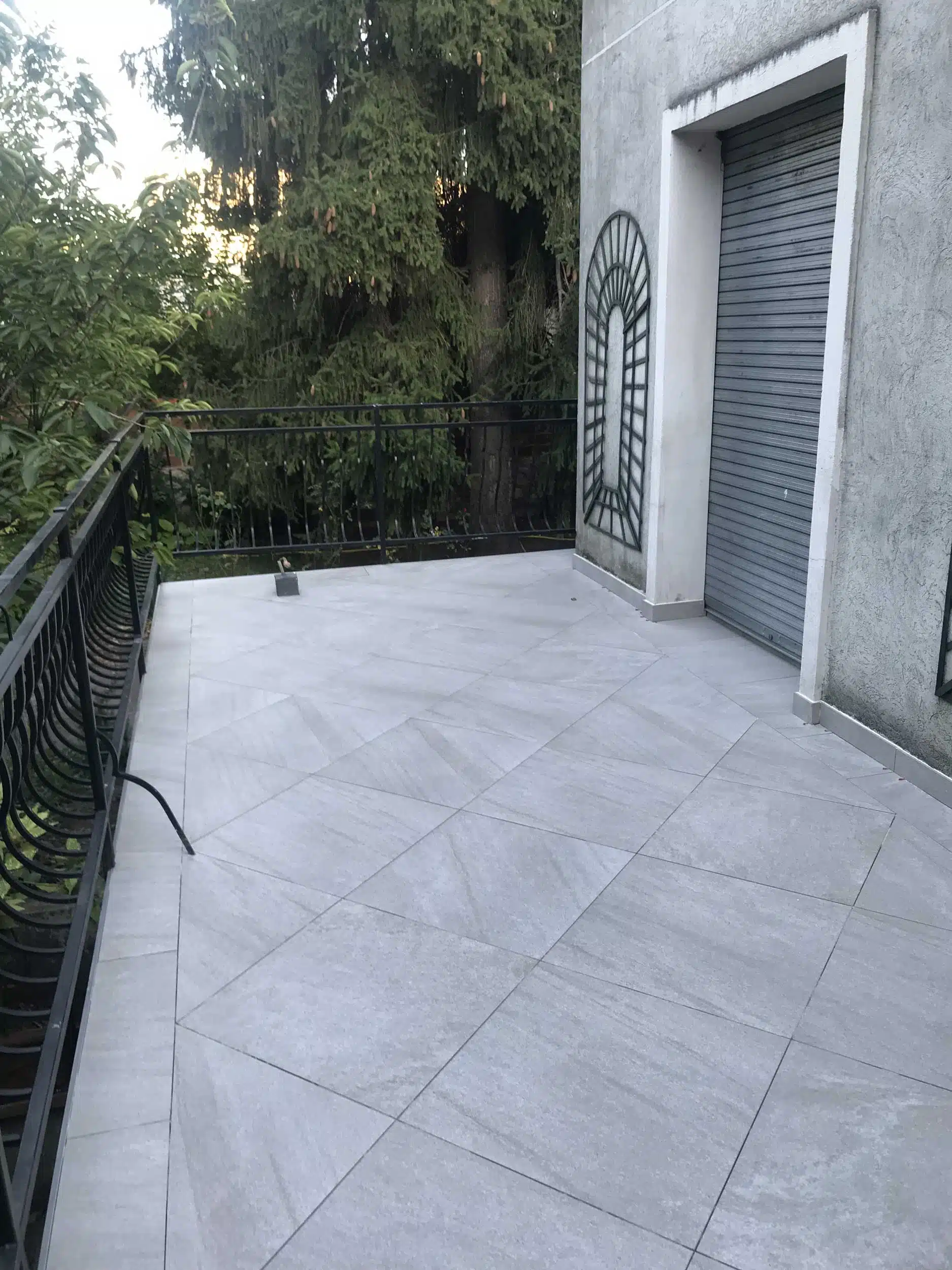 rénovation terrasse élégante à paris - entreprise abramo avec carrelage extérieur et garde-corps en métal.
